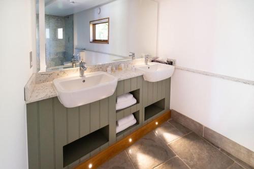 a bathroom with two sinks and a mirror at Watership Down Inn in Whitchurch