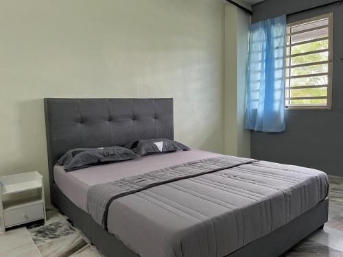 a bedroom with a large bed with a blue window at Homestay Malim Nawar in Malim Nawar