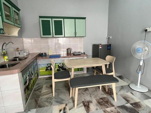 cocina con mesa, sillas y ventilador en Homestay Malim Nawar, en Malim Nawar