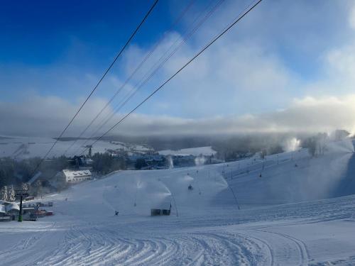 a snowy ski slope with a ski lift at k1 sporthotel - Bike & Ski inklusive Hotel in Kurort Oberwiesenthal