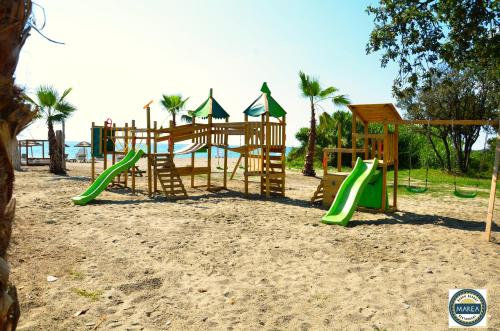 um parque infantil na praia com escorrega em Residence Marea Resort em Santa-Lucia-di-Moriani