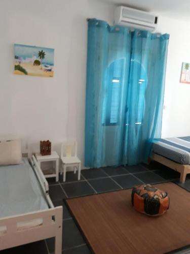 - une chambre avec 2 lits et un rideau bleu dans l'établissement Dar Chick Yahia Ile De Djerba, à Mezrane