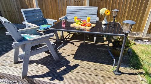a table with a plate of fruit on a deck at Worthingtons by Spires Accommodation A cosy and comfortable home from home place to stay in Burton-upon-Trent in Burton upon Trent
