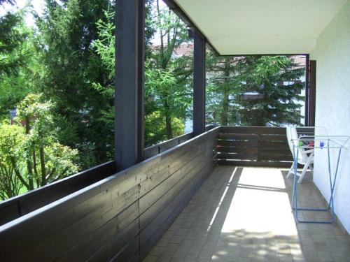 einen Balkon mit einer Bank, einem Tisch und Fenstern in der Unterkunft Ferienwohnungen Schelhas in Prien am Chiemsee