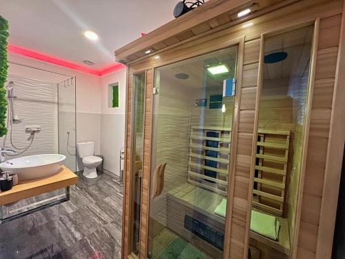 a bathroom with a glass shower and a sink at LTE Apartments in Maribor