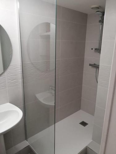 une douche avec une porte vitrée à côté d'un lavabo dans l'établissement STUDIO pied des pistes et commerces, à Les Deux Alpes