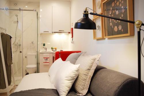Habitación con sofá, lámpara y baño. en Vila Santa Marinha, en Lisboa
