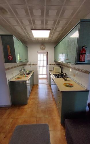 cocina grande con armarios verdes y suelo en Villa Rosa - La Marina Urbanisation en San Fulgencio