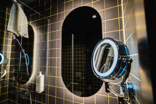 a bathroom with a mirror on a tiled wall at ibis Lviv Center in Lviv