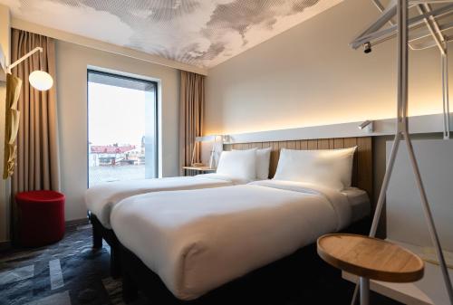 リヴィウにあるibis Lviv Centerのベッド2台と窓が備わるホテルルームです。