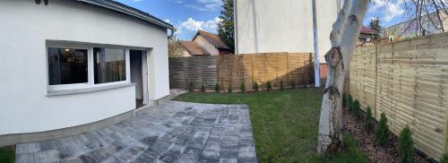 a backyard with a brick walkway next to a fence at Pokoje Gościnne Atelier in Orneta