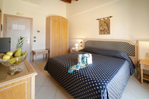 a bedroom with a bed with a blue and white bedspread at Hotel Villa Romana in Porto Empedocle
