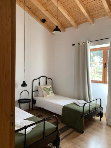 1 dormitorio con 2 camas y ventana en Herdade Da Maridona - Agroturismo, en Estremoz