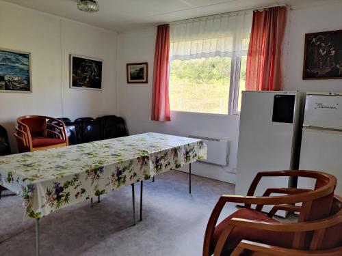 una sala da pranzo con tavolo e frigorifero di Sólbrekka Guesthouse a Mjóifjörður