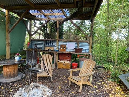 a gazebo with two chairs and a table at The Hobbit House and Secret Garden in Taunton