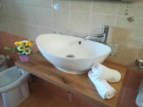 - un lavabo blanc sur un comptoir en bois dans la salle de bains dans l'établissement SOLE e MARE Luxury Home, à San Salvo
