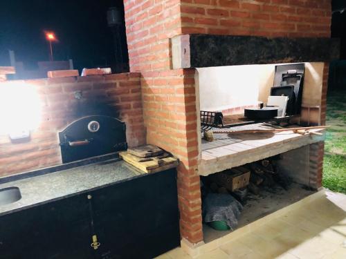 a kitchen with a brick wall with a stove at Casa quinta La Justina in Concepción del Uruguay