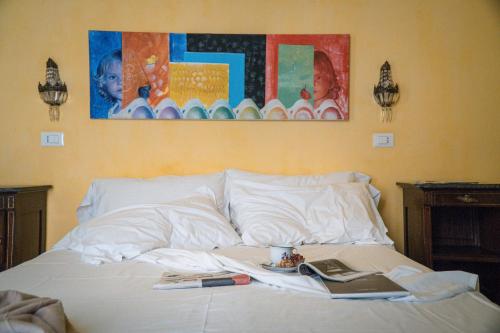 a bed with a laptop and a book on it at Casa D'aria in Catania