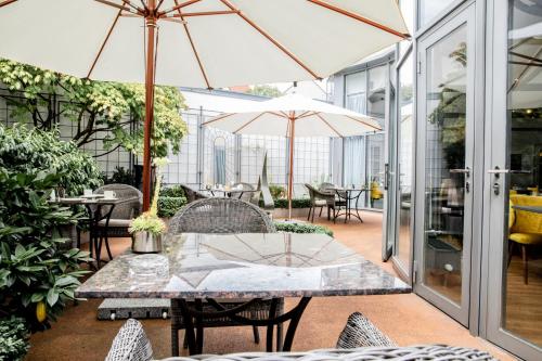 a patio with a table and chairs with umbrellas at Altstadthotel Messerschmitt in Bamberg
