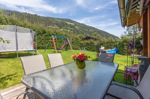a glass table with a vase of flowers on a patio at Ferienwohnungen Behamhof in Neukirchen am Großvenediger