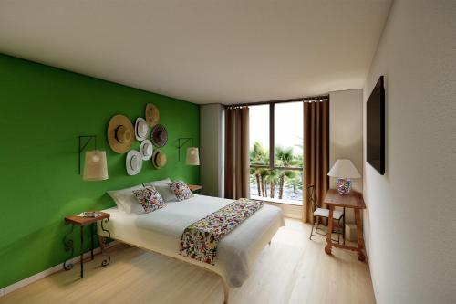 een slaapkamer met groene muren, een bed en een raam bij Les Rivages de Beauval in Saint-Aignan