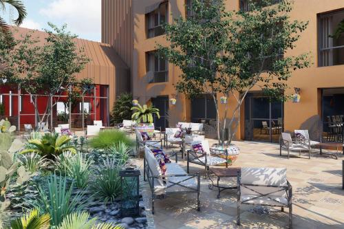 een binnenplaats met stoelen en planten voor een gebouw bij Les Rivages de Beauval in Saint-Aignan