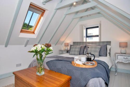 een slaapkamer met een bed met een vaas met bloemen op een tafel bij Finest Retreats - Dunira in Falkland