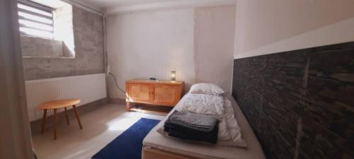 Habitación pequeña con cama y mesa de madera. en Accommodation for working team or big family, en Odense