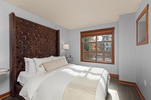 a white bedroom with a large bed and a window at Powderhorn Lodge 209 in Solitude
