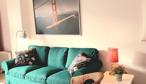 un sofá verde en una sala de estar con lámpara en Maravilloso apartamento, en Nerja