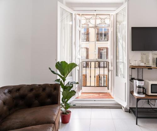 ein Wohnzimmer mit einem Sofa und einem großen Fenster in der Unterkunft Gran Via Experience in Madrid