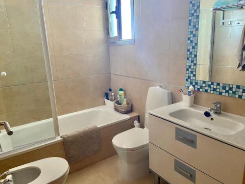 uma casa de banho com um lavatório, um WC e uma banheira em Relax em La Manga del Mar Menor