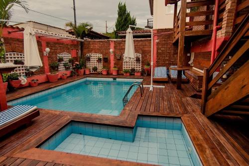 a swimming pool with a wooden deck at Pousada Brilho da Serra in Tiradentes