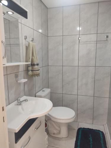 a white bathroom with a toilet and a sink at Apartamento no coração de Porto Alegre in Porto Alegre