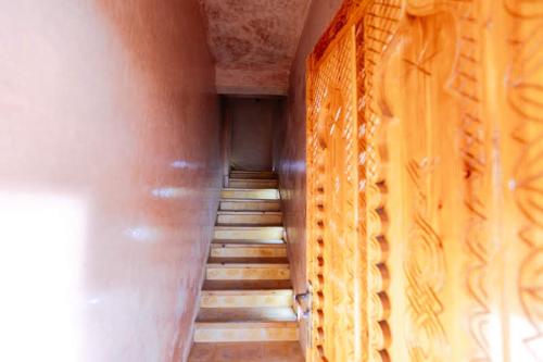 a hallway with stairs in a building with a wall at Chillax room salon 2P in Agadir