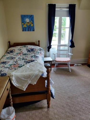 a bedroom with a bed and a window and a chair at 5449 Emerald home in Dewittville