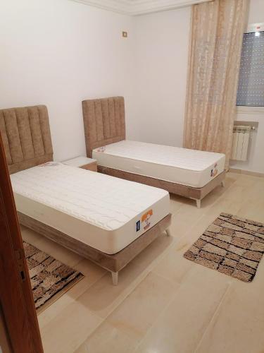 - 2 lits dans une chambre avec 2 chaises et un matelas dans l'établissement maison rabat, à Rabat