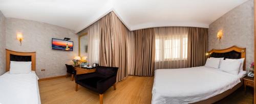 a hotel room with two beds and a chair at Aprilis Hotel - Special Category in Istanbul