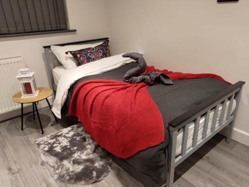 a bedroom with a bed with a red blanket at Sounds of Stars in Mansfield