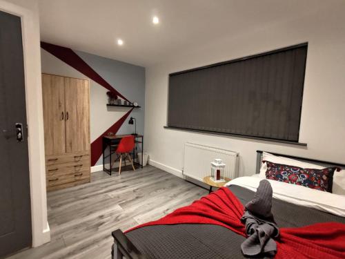 a bedroom with a bed with a red blanket on it at Sounds of Stars in Mansfield