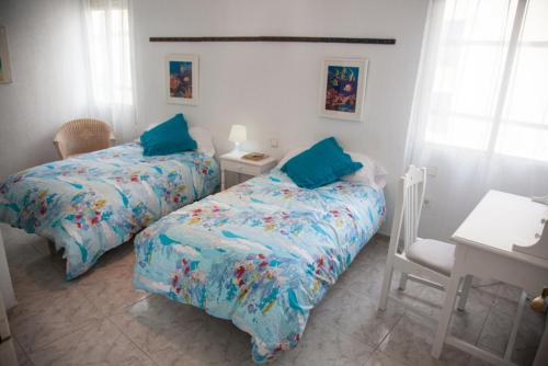 a bedroom with two beds and a table and a desk at SEAFRONT UNBEATABLE LOCATION a in Benidorm