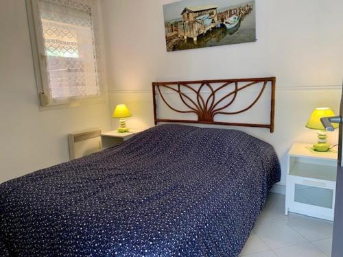 une chambre avec un lit avec une couette bleue dans l'établissement Appartement cosy à 50 m de la plage à Bouzigues avec terrasse et parking privé. - FR-1-604-13, à Bouzigues