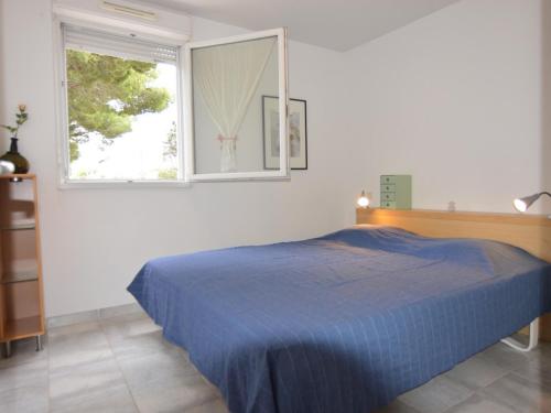une chambre avec un lit bleu et une fenêtre dans l'établissement Bel appartement climatisé à Mèze avec parking et accès à la plage - FR-1-604-20, à Mèze