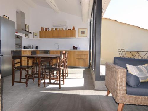 une cuisine et une salle à manger avec une table et des chaises dans l'établissement Charmant Appartement Climatisé avec Terrasse, 2 Chambres, au Cœur de Mèze, près de l’Étang de Thau - FR-1-604-10, à Mèze