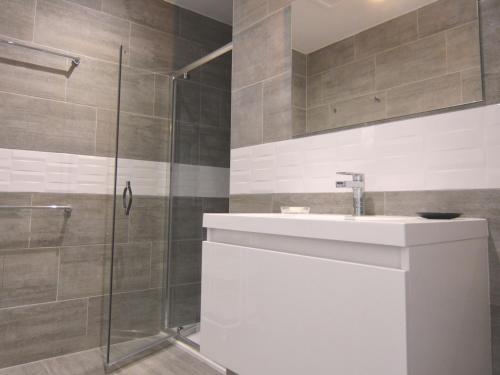 uma casa de banho com um lavatório e um chuveiro em Appartement Mèze, 3 pièces, 4 personnes - FR-1-604-10 em Mèze