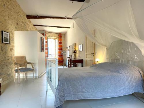 une chambre avec un lit et une chaise dans une pièce dans l'établissement Charmante maison climatisée avec cour privée à Bouzigues, idéal pour vacances en famille ou entre amis - FR-1-604-16, à Bouzigues