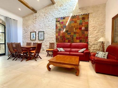 un salon avec un canapé rouge et une table dans l'établissement Charmante maison climatisée avec cour privée à Bouzigues, idéal pour vacances en famille ou entre amis - FR-1-604-16, à Bouzigues