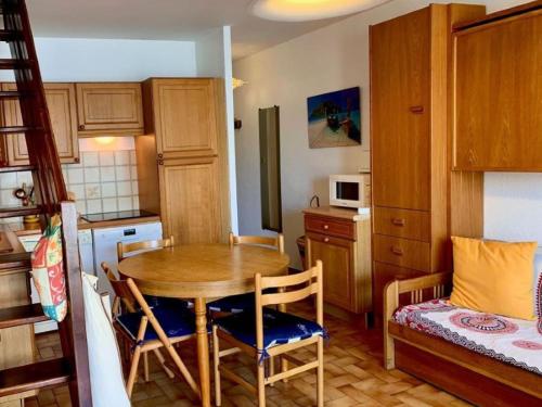 une cuisine avec une table et des chaises dans une pièce dans l'établissement Appartement Duplex à Mèze avec Terrasse et Garage Proche Port et Plage - 2 Clés - FR-1-604-30, à Mèze