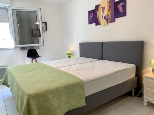 - une chambre avec un lit et une couverture verte dans l'établissement Appartement Mèze, 3 pièces, 4 personnes - FR-1-604-27, à Mèze