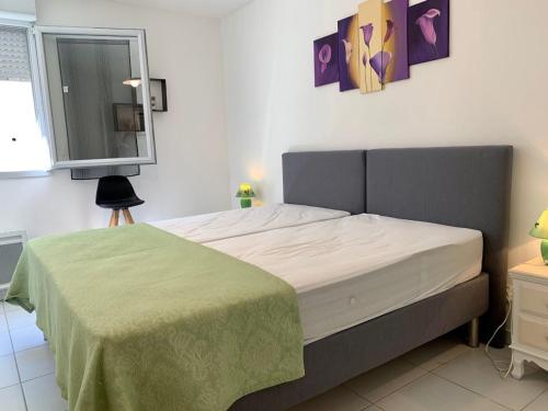 une chambre avec un lit avec une couverture verte dans l'établissement Appartement 3 étoiles, calme et confort à deux pas de la plage et du port de Mèze - FR-1-604-27, à Mèze
